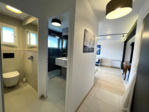 La salle de bains est pourvue de toilettes, d'un lavabo et d'un miroir. dans l'établissement New appartment 180m from the beach, à Ploemeur