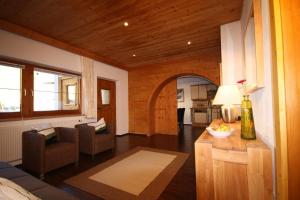 a living room with a couch and a chair and a table at Kalle's Familien-Appartements in Gerlos