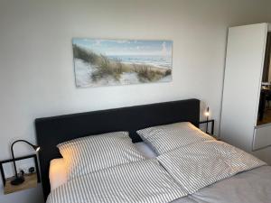 um quarto com uma cama e uma fotografia de uma praia em Deichperle Krautsand em Drochtersen