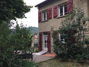 une maison avec une porte rouge et une terrasse couverte dans l'établissement Villa Delphina, à Vernet-les-Bains