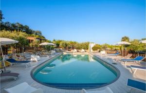 einen Pool mit Stühlen und Sonnenschirmen in einem Resort in der Unterkunft Awesome Home In Montefiore Dellaso With Jacuzzi in Montefiore dellʼAso