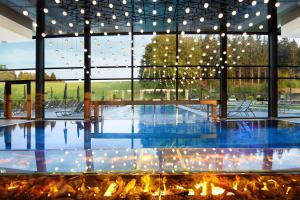 a large room with a fireplace and a large window at Wellness & Naturresort Reischlhof in Wegscheid