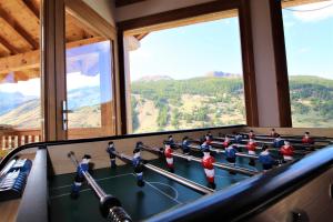 a ping pong table in a room with windows at Charming Chalet w/ Mountain & Slope Views, Jacuzzi in Vars