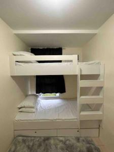 a white bunk bed in a small room at Condo in Ortigas (Kimea Suite) in Manila