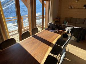 a table and chairs in a room with a large window at Chalet La Mahure in La Toussuire