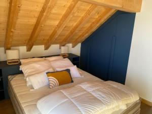 a bed in a room with a wooden ceiling at Chalet La Mahure in La Toussuire