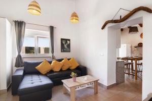 ein Wohnzimmer mit einem blauen Sofa und einem Tisch in der Unterkunft Casa de Aloe in Paderne