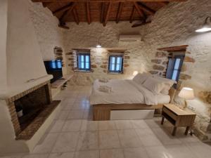 um quarto com uma cama e uma lareira em Marianta house em Areopoli