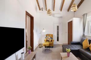ein Wohnzimmer mit einem Sofa und einem TV in der Unterkunft Casa de Aloe in Paderne