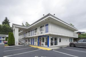 a building with a car parked in a parking lot at Motel 6-Seattle, WA - Airport in SeaTac