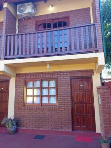 a house with a balcony and two doors at Alojamiento céntrico florida in Puerto Iguazú