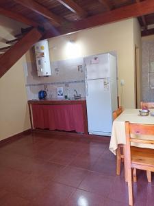 uma cozinha com uma mesa e um frigorífico branco em Alojamiento céntrico florida em Puerto Iguazú