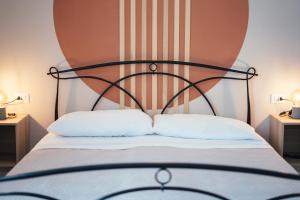 een bed met een zwart hoofdeinde en 2 witte kussens bij La Piccola Lady in La Spezia