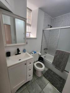 a bathroom with a toilet and a sink and a shower at Spacious 3 bedroom apartment mins to NYC! in Union City