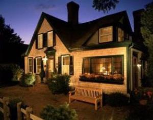 ein Haus mit einer Bank davor in der Unterkunft Snug Cottage in Provincetown