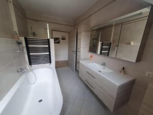 a bathroom with a white tub and a sink and a bath tub at FeWo beim Oldtimer in Rees +18 photos