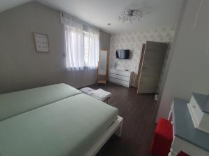 a bedroom with a large white bed and a bathroom at FeWo beim Oldtimer in Rees