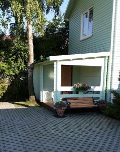 a house with a bench in the front yard at Guest house Rasa in Palanga