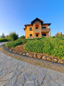 uma casa numa colina com uma estrada de paralelepípedos em Villa Costanza em Bobbio