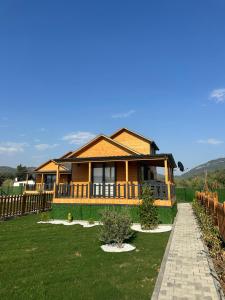 a large wooden house with a green yard at Lake House Kayacık in Dalaman