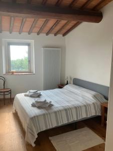 a bedroom with a bed and a window at Podere La Croce Toscana in Solata