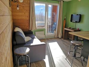 a living room with a couch and a table at Au pied des pistes avec parking Entièrement rénové in LʼHuez