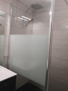 a shower with a glass door in a bathroom at Au pied des pistes avec parking Entièrement rénové in LʼHuez