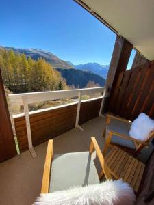 a balcony with two chairs and a view of the mountains at Au pied des pistes avec parking Entièrement rénové in LʼHuez