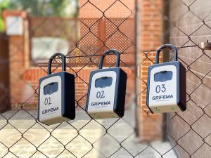 Ein Zaun mit zwei Seifenbehältern, die darauf hängen. in der Unterkunft Casa Grande CASA CAFE MADRID 22 PERSONAS in Pozuelo de Alarcón