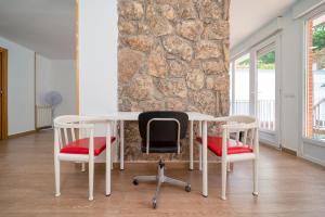 un tavolo bianco con due sedie e un muro di pietra di Casa Grande CASA CAFE MADRID 22 PERSONAS a Pozuelo de Alarcón