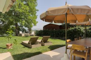 a patio with a table and an umbrella at Hidden Gabicce in Gabicce Mare