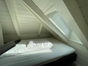 - un petit lit mansardé avec fenêtre dans l'établissement Stunning Hilltop Nest Unparalleled Views at BnB Ap 17, à Stavanger