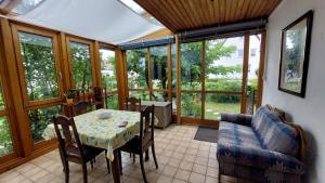 a conservatory with a table and chairs and a couch at Villa Lotte in Lichtenfels