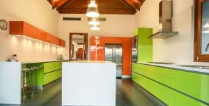 uma cozinha colorida com armários verdes e laranja em Sunny Vacation Villa No 60 em San Rafael del Yuma