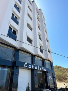 a tall white building with a sign on it at Hotel Cataleya Al-Hoceima in Al Hoceïma