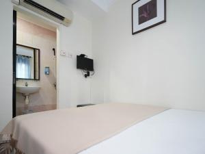 a white room with a bed and a sink at Amrise Hotel in Singapore