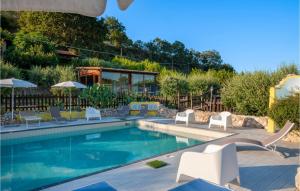 - une piscine avec des tables et des chaises blanches dans l'établissement Cozy Home In San Giovanni With Wifi, à Montefiore dellʼAso