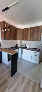 Una cocina con gabinetes blancos y una encimera de madera. en Aqua Park Lux Jagodina, en Trnava