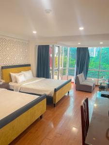 a bedroom with two beds and a chair and a window at A25 Hotel - 251 Hai Bà Trưng HCM in Ho Chi Minh City