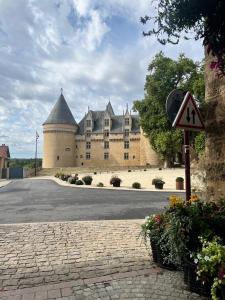 Le Chalet du Coin في Videix: قلعة كبيرة مع علامة الطريق أمامها