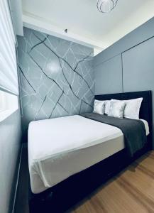 - une chambre avec un lit et un mur en pierre dans l'établissement JA1 STAYCATION at TREES RESIDENCE, à Manille