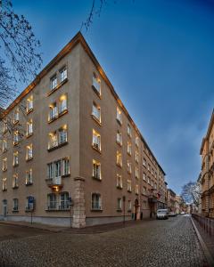 a large brick building on a cobblestone street at Garamond a Tribute Portfolio Hotel in Kraków