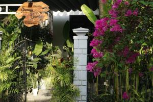 wejście do ogrodu z fioletowymi kwiatami w obiekcie Sunny Garden Homestay w Hoi An