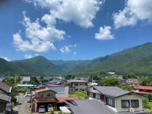 uma pequena cidade com montanhas ao fundo em 金桂苑 em Fujikawaguchiko