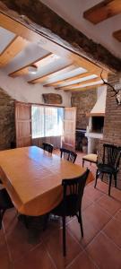 a dining room with a large wooden table and chairs at Candela de la Murtera in Chelva