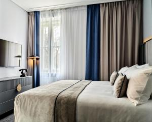 a bedroom with a large bed and a window at Garamond, a Tribute Portfolio Hotel, Krakow Old Town - Adults Only in Krakow +21 photos