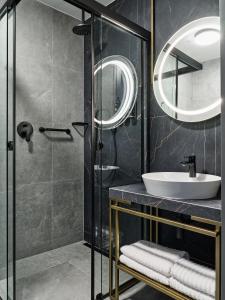a bathroom with a sink and a mirror at Garamond a Tribute Portfolio Hotel in Kraków