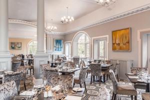 a restaurant with tables and chairs in a room at The Headland Hotel & Spa in Torquay