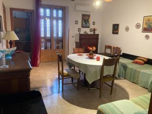 a living room with a table and a bedroom at Bed & Breakfast 5 Di Spade in Gioiosa Marea