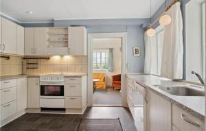 una cocina con armarios blancos y fregadero en 2 Bedroom Beautiful Home In Ringe, en Ringe